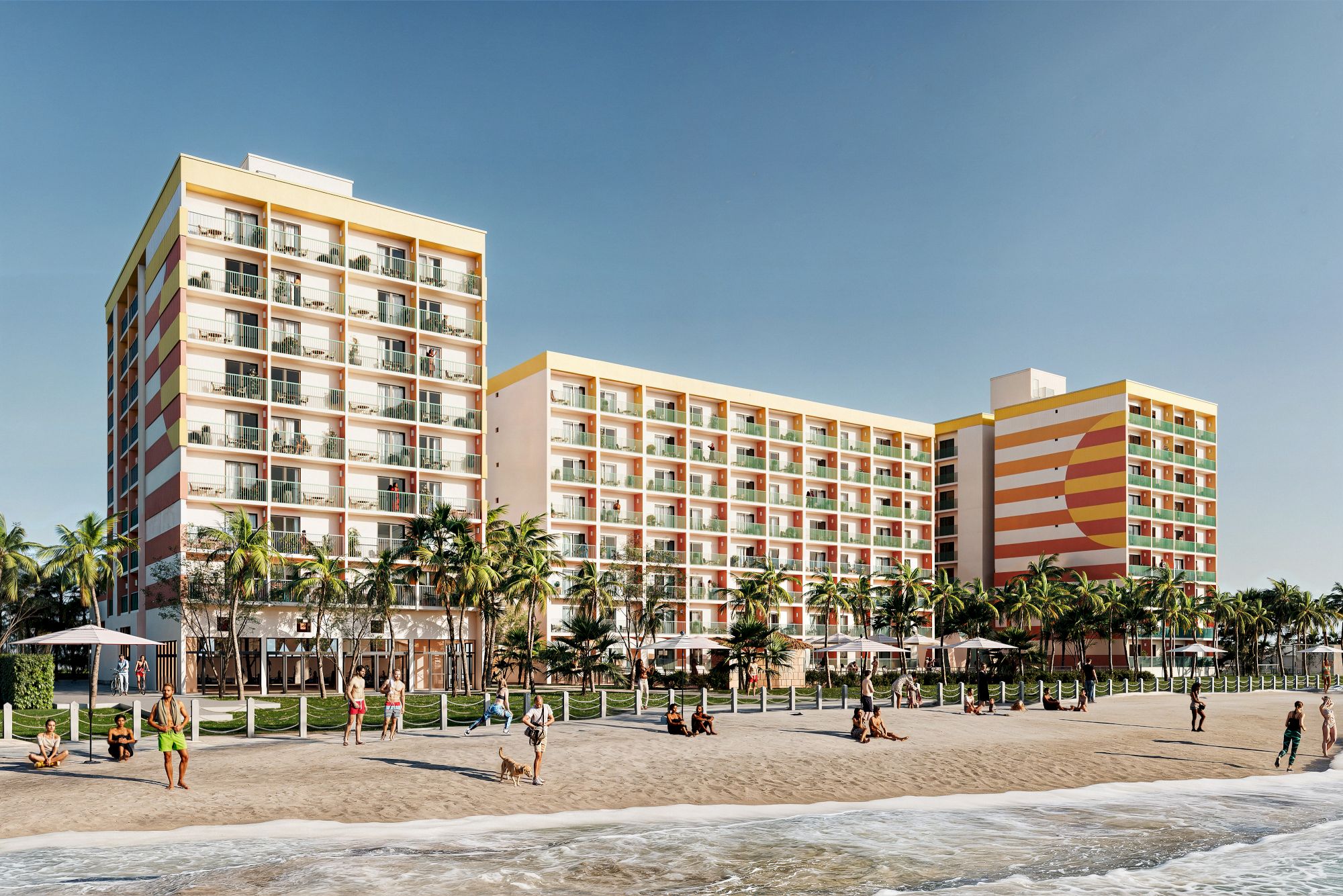 A beachfront hotel with colorful balconies and palm trees, people enjoying the sandy beach and ocean waves under a clear sky.